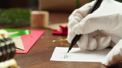 Papai Noel com presentes na mesa de madeira, mãos escrevendo cartas, lista de desejos para feriados de Natal ou novos