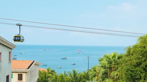 Modern Cable Car Cabin Ride Over Tropical Seaside with Fishing Boats and Blue Ocean on Phu Quoc
