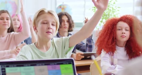 Students Raising Hands in Bright Classroom Lesson