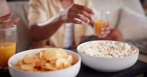 Reaching for Popcorn While Relaxing at Home