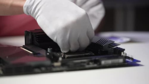 Closeup Side View of Unrecognizable Repairman in Gloves Installing PC CPU Air Cooling System
