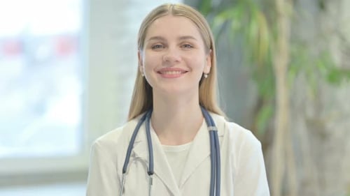 Smiling Young Woman Doctor in White Coat