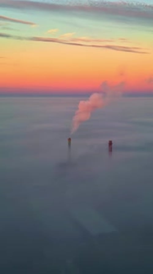Vertical Aerial of Smokestack Above Sea of Clouds at Sunset