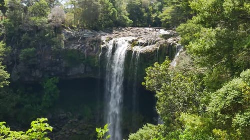 Lush Waterfall in a Green Forested Landscape