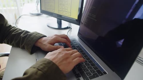 Mãos de um programador irreconhecível criando um novo software que funciona em um laptop