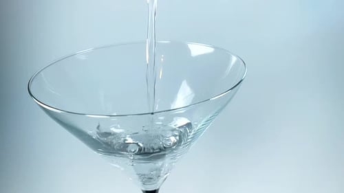 Clear Liquid Being Poured into a Martini Glass