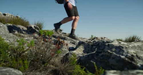 Man Hiking on Rocky Mountain Top on Sunny Day