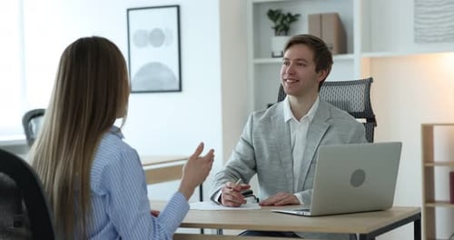 Smiling recruiter and candidate having job interview at table in office