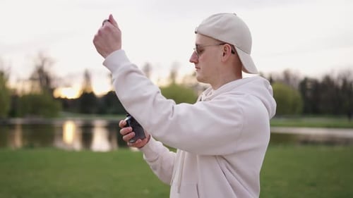 Confident male remove cap from perfume bottle and spray aromatic liquid mist