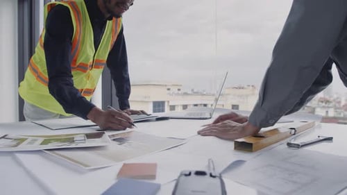 Construction Team Reviewing Blueprints in Modern Office