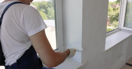 Man Painting Wall in White Color with Roller