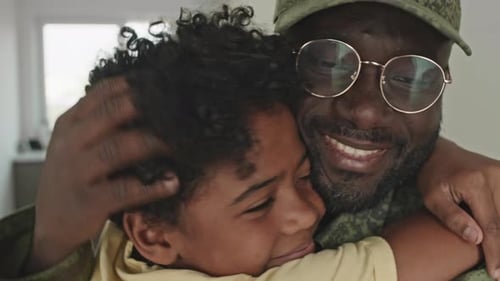 Heartwarming Hug Between Child and Man Indoors