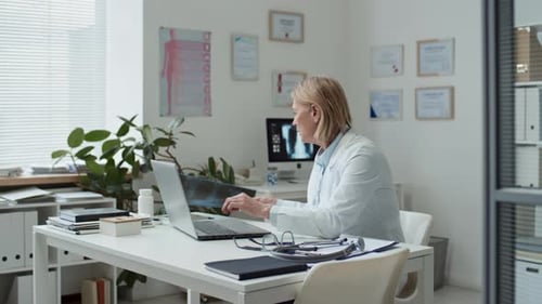 Medical Professional Examining X-Ray in Bright Office