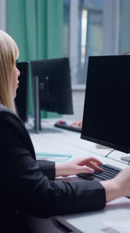 Focused Professional Engaged in Computer Work at a Modern Office Desk Showcasing Concentration and