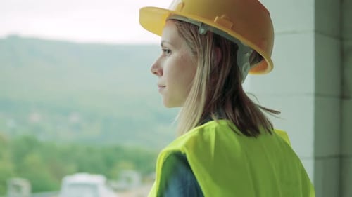 Young woman construction worker inspecting a building project indoors