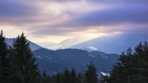 Clouds at Sunset Over a Snowy Hilly Landscape