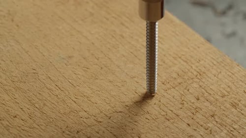 Drill Driving Screw into Wood Board Close Up