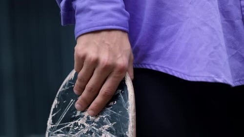 Closeup Man Hand Holding Skateboard Outdoor. Unknown Young Hipster Preparing Riding On