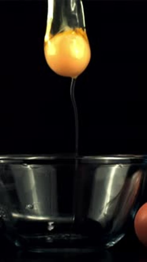 Rohes Ei in Superzeitlupe fällt in die Schale mit Spritzern, die mit einer Hochgeschwindigkeitskamera mit 1000 Bildern pro Sekunde gefilmt wurden