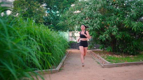 Middle Age Woman Jogging Summer Day in City Park