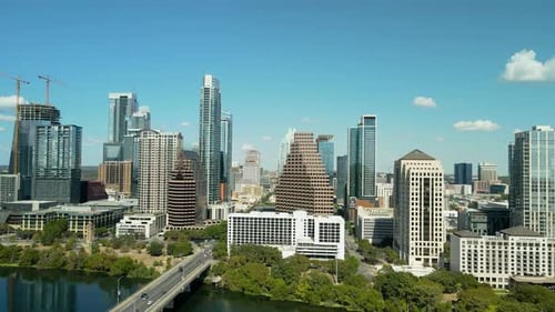 Aerial drone shot of Downtown Austin on a sunny day, with a pull-out zoom revealing the city alongsi