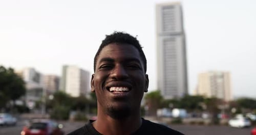 Young african man smiling on camera in the city