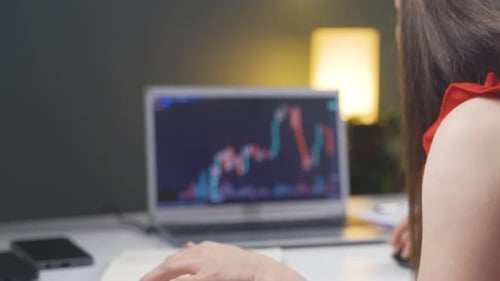 Investor looking at the stock market chart. She claps when she wins.