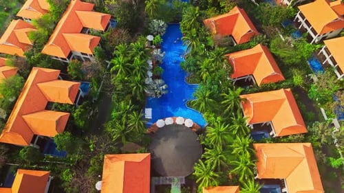 Aerial Perspective Revealing Verdant Landscape Surrounding Curving Azure Pool Amid Tropical Resort