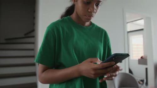 Young Adult Using Smartphone Indoors at Home