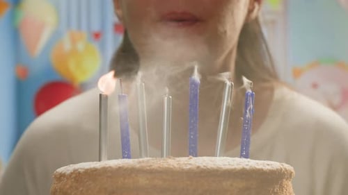 Woman Kid Child Blowing Candles on Birthday Cake Macro Close Up of Some Unlit Candles and Just One