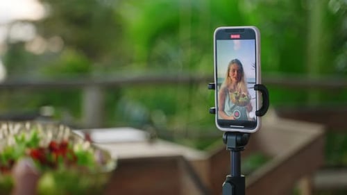 Smartphone Screen with Young Woman Blogger Making Selfie Video with Green Salad in Tropical Island