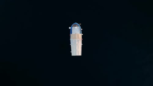 Vertical Video of a Fishing Boat on a Dark Blue Sea Background Static Frame Aerial View