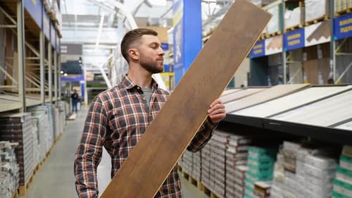 Man Inspecting Wood Flooring in Hardware Store