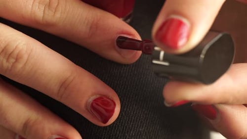 Close Up Of Woman Applying Red Nail Polish