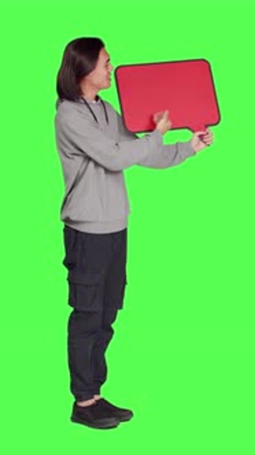 Side View of Young Guy Shows Speech Bubble in Studio