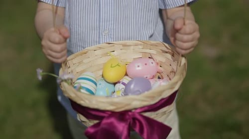 Nahaufnahme des Ostereierkorbs, Kinderhände mit traditionellen Osterdekorationen