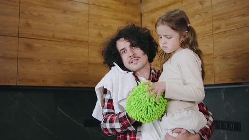 Busy Father Holding Daughter While on Phone