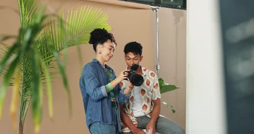 People, model and photographer conversation in studio, art and camera to review for direction