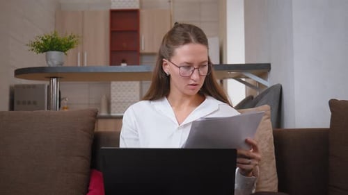 Businesswoman with serious expression looking at documents