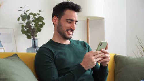 Adult Man Using Smartphone on Couch Indoors