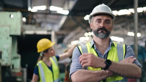 Portrait of confidence male engineer foreman in arms crossed looking at camera at factory