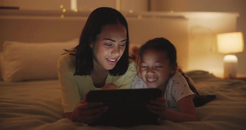 Woman and Child Using Tablet on Bed