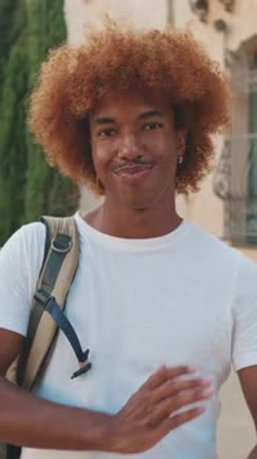 Portrait of a young smiling guy on the street in summer
