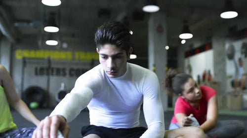 People In Modern Gym Stretching Their Legs.