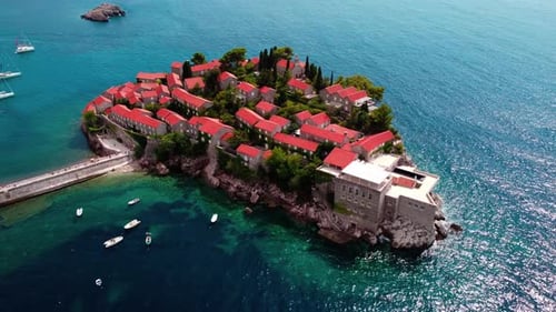 Aerial view of Sveti Stefan island and shore in a beautiful summer day, Montenegro from flying drone