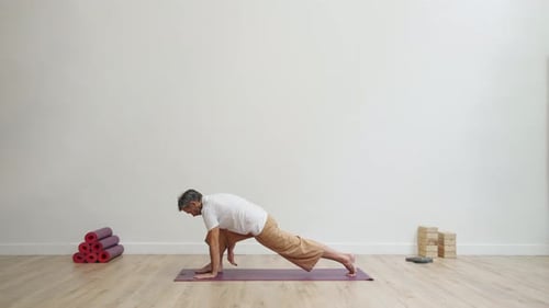 Man practicing supine twist in green garden with peaceful focus