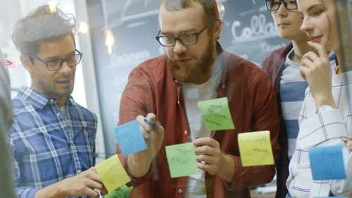 Creative Team Brainstorming Ideas on a Glass Board