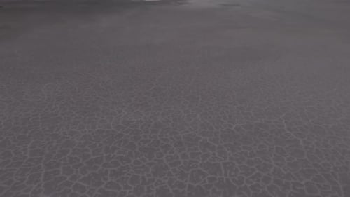 Drone slow low approach over Bonneville Salt Flats with water reflecting the sky and clouds