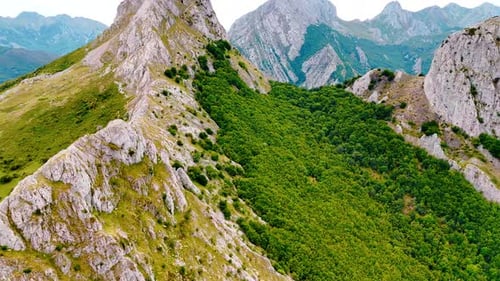 Über den kahlen Bergrücken mit üppigem Grün, das am Hang leuchtet.