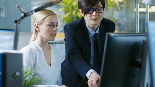 In the Office Young Businesswoman Sitting at Her Desk Talks with Her Manager, they're pointing at C